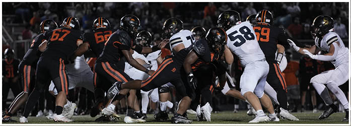 A group of football players on a field. Description generated by AI