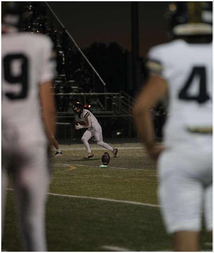 A group of football players wearing black and white uniforms. Description generated by AI