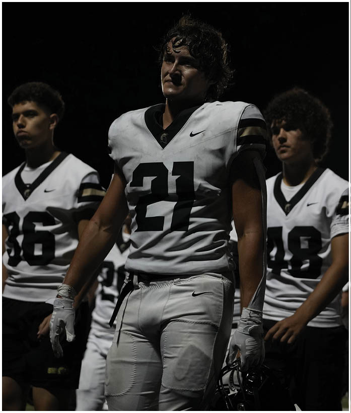 A group of football players wearing black and white uniforms. Description generated by AI