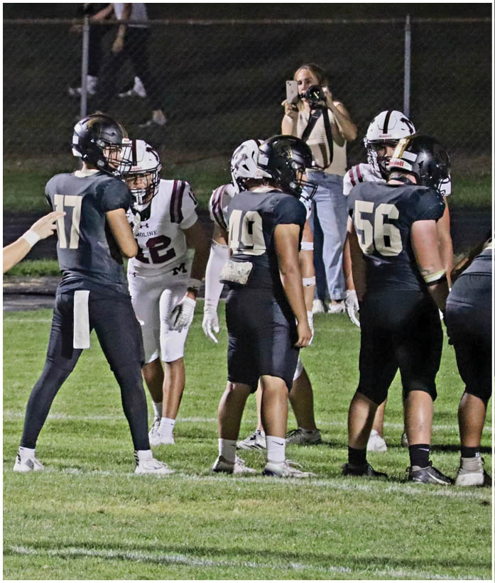 A group of football players wearing black and white uniforms. Description generated by AI