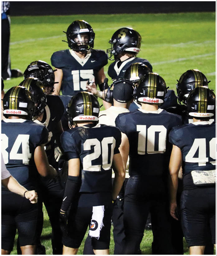 A group of football players wearing black and white uniforms. Description generated by AI