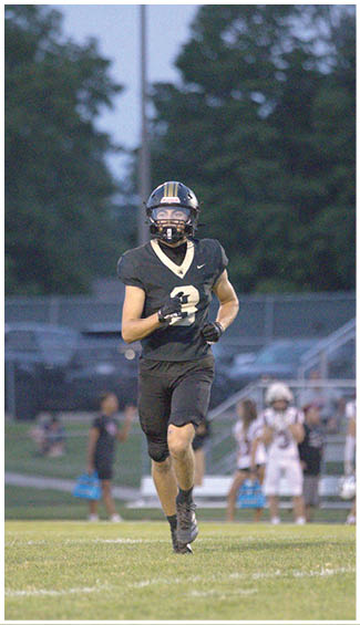 A football player running on the field. Description generated by AI