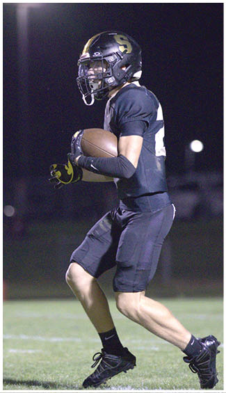 A football player running on the field. Description generated by AI