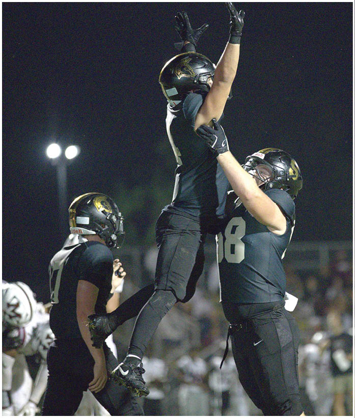 A group of football players wearing black and white uniforms. Description generated by AI
