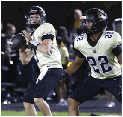 Two people wearing black helmets and sports gear appear to be engaged in an outdoor nighttime activity. Description generated by AI