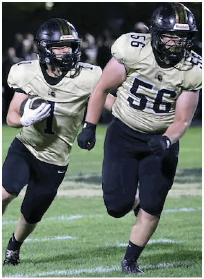 A person wearing a football uniform with the number one is running on a field while holding a football. Description generated by AI