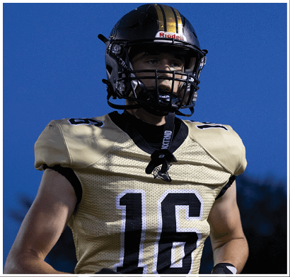 A person wearing a black and gold football helmet and a matching jersey looks focused against a clear blue sky. Description generated by AI