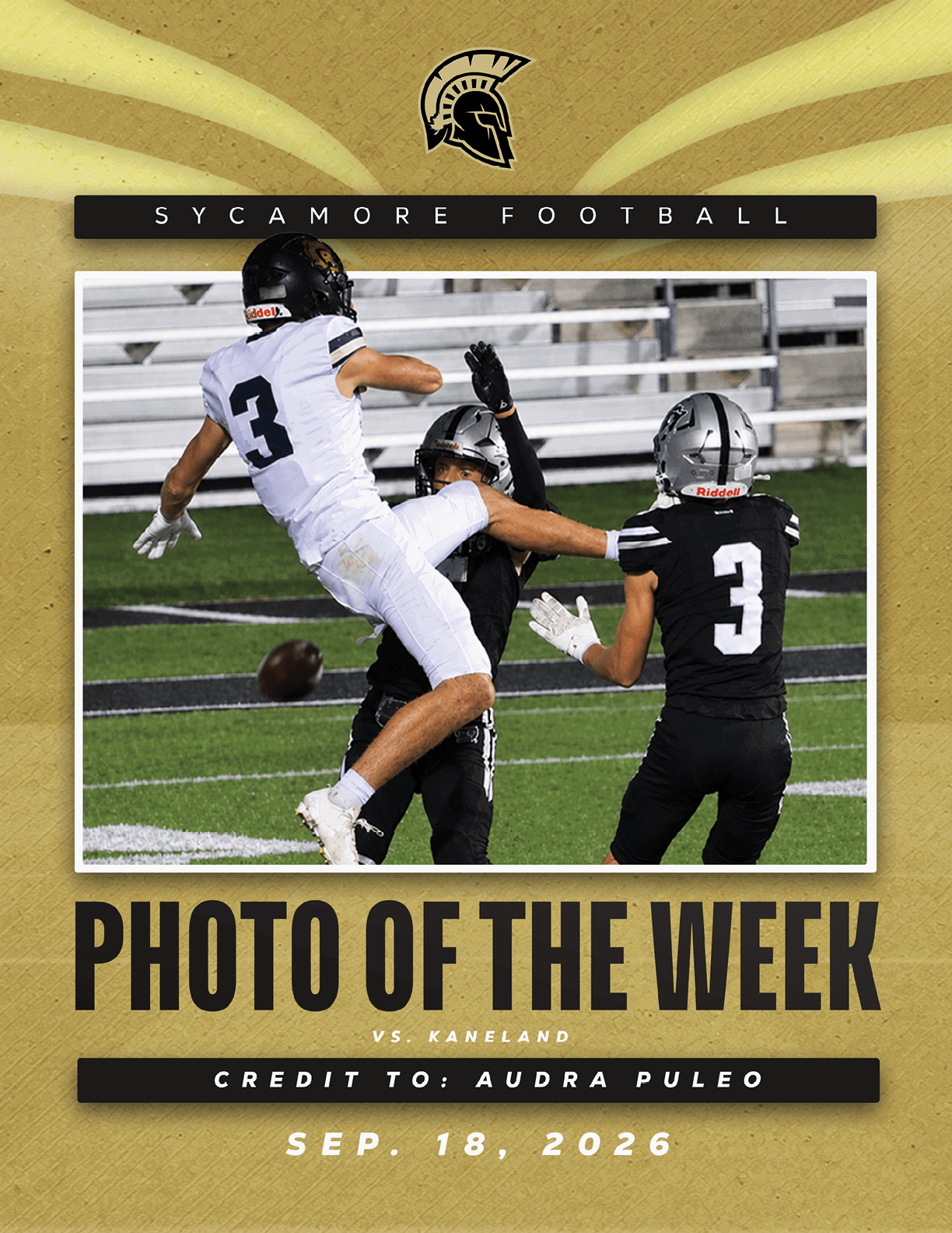 Two people in black football uniforms and one person in a white football uniform are actively engaged in a play on a football field with a ball in mid-air. Description generated by AI