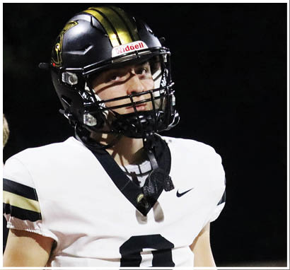 A person wearing a white sports jersey with a black collar and the number 8 printed on the front. Description generated by AI