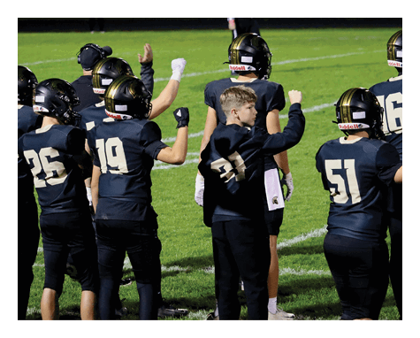 A group of young men wearing black jerseys with the word “Vista" on the front are celebrating a victory. AI generated content