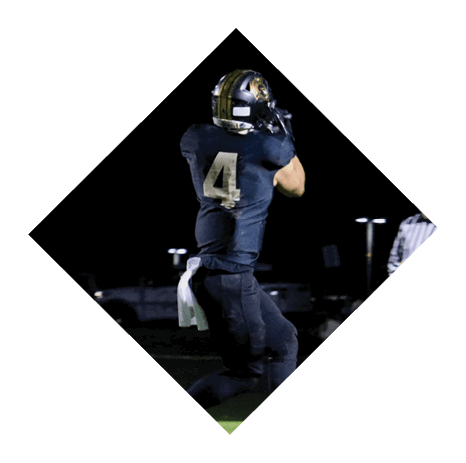 A football player wearing a black jersey with the number 3 kneels on the field. AI generated content