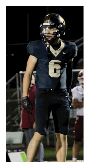 A football player is kneeling on the field, wearing a green jersey and a helmet. AI generated content