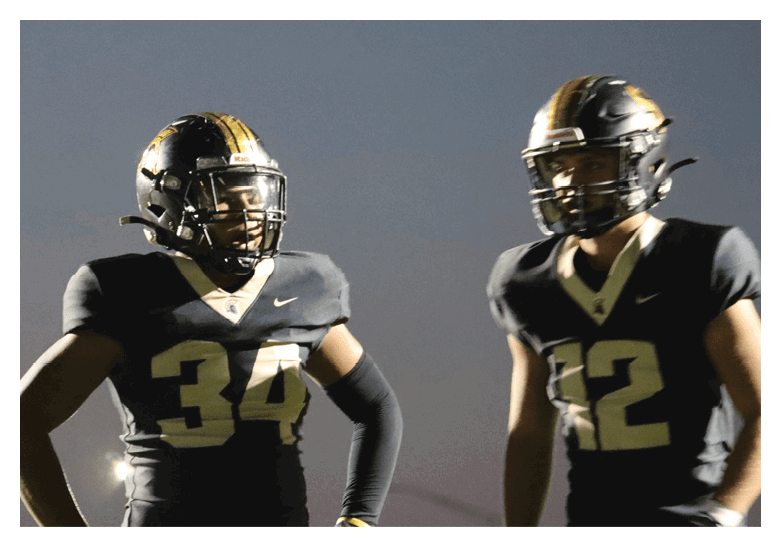 A group of football players on a field, one of them is running with a football. AI generated content