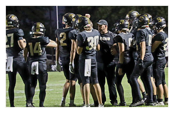 A group of football players wearing headphones and smiling. AI generated content