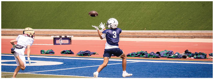 A football player wearing a blue and white uniform. Description generated by AI