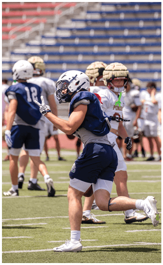 A football player catching a ball. Description generated by AI