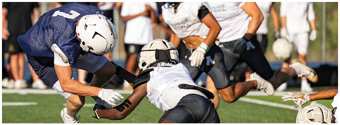 A football player wearing a blue and white uniform. Description generated by AI
