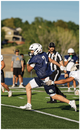 A football player catching a ball. Description generated by AI