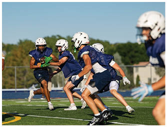 A group of football players on a field. Description generated by AI