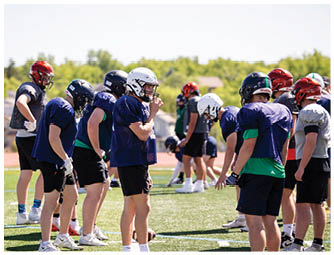 A group of football players on a field. Description generated by AI
