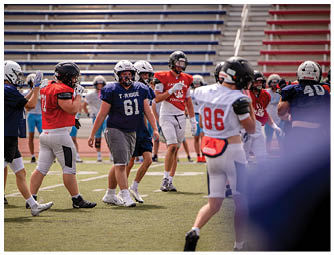 A group of football players on a field. Description generated by AI