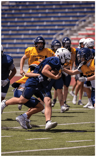 A football player catching a ball. Description generated by AI