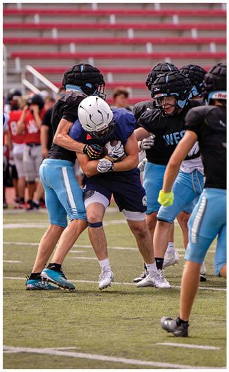 A football player catching a ball. Description generated by AI