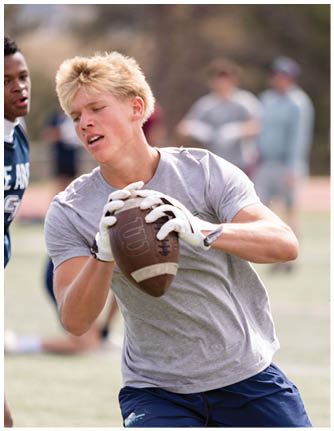 A football player catching a ball. Description generated by AI
