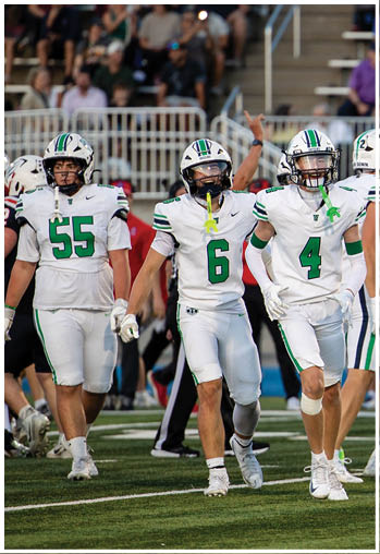 A group of football players celebrating a touchdown. Description generated by AI