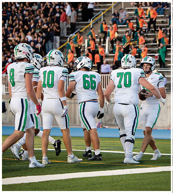 A group of football players celebrating a touchdown. Description generated by AI