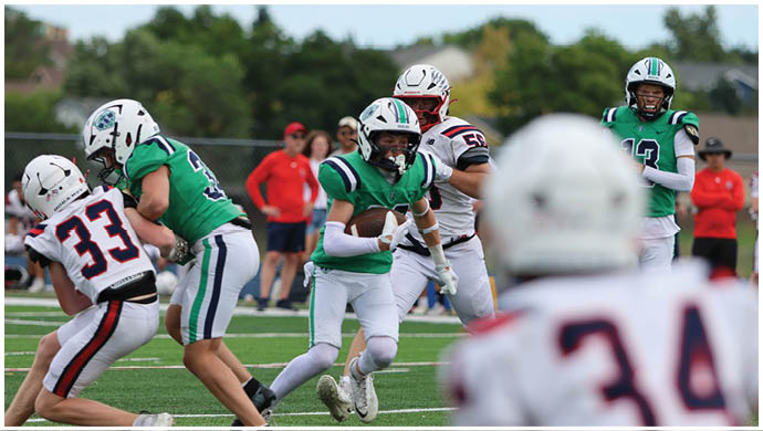 Three football players in blue and white uniforms running on a field. Description generated by AI
