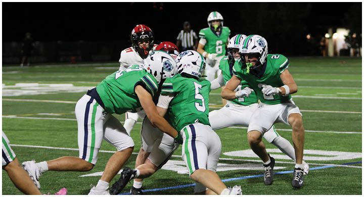 A group of football players on a field. Description generated by AI