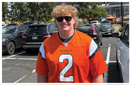 A football player wearing a blue and red jersey. Description generated by AI