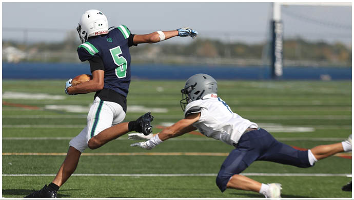 Three football players in blue and white uniforms running on a field. Description generated by AI