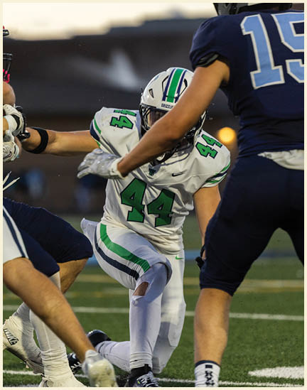 A football player wearing a black jersey with the number 11 on it. Description generated by AI