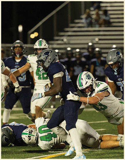 Three men wearing green and white uniforms are standing on a field. Description generated by AI
