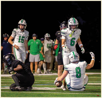 A group of football players posing for a picture. Description generated by AI