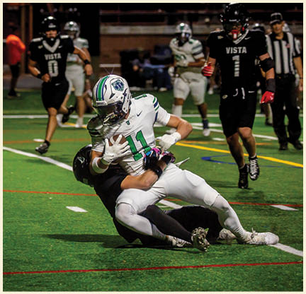 Two football players wearing black jerseys with the number 11 on them. Description generated by AI