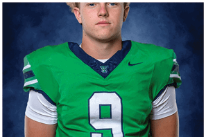 A young man wearing a white jersey with the number 10 on it. Description generated by AI