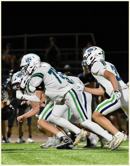 A group of football players on a field. Description generated by AI