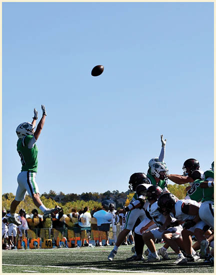 A group of football players on a field. Description generated by AI