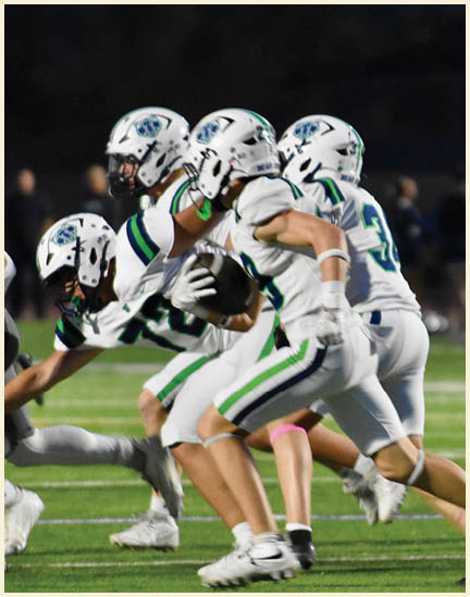 A group of football players on a field. Description generated by AI