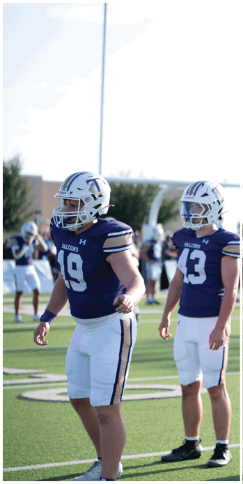 Two football players celebrating on the field. Description generated by AI