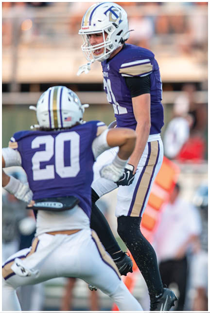 A football player wearing a blue and white uniform. Description generated by AI