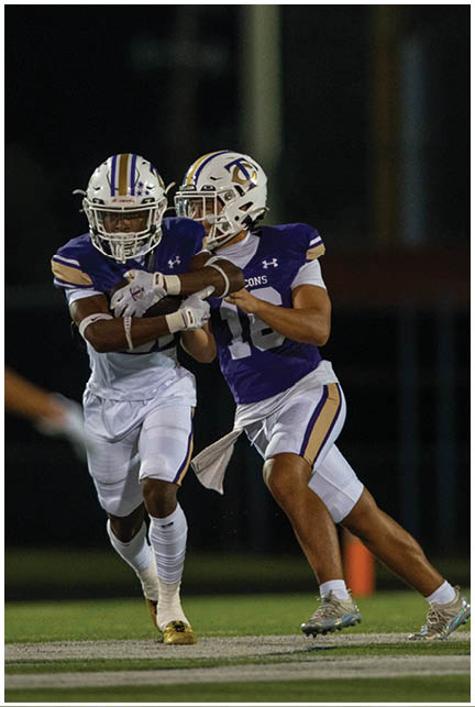 A football player wearing a blue and white uniform. Description generated by AI