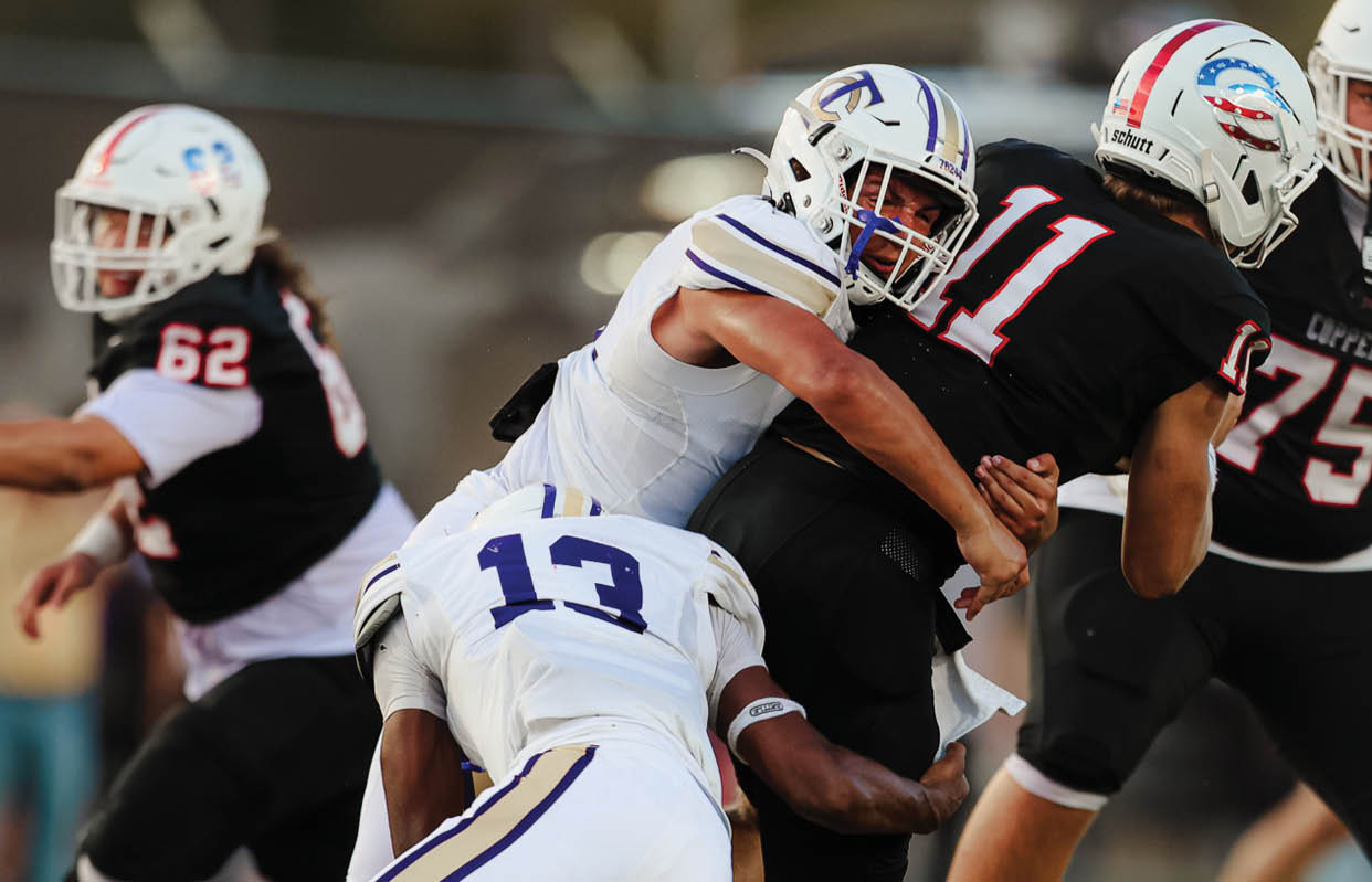 A football player wearing a black and white jersey with the number 55 on it. Description generated by AI