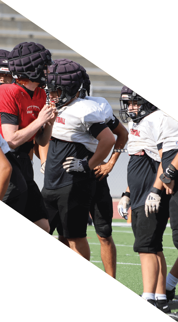 A football player wearing a black helmet and white jersey is holding a football in his hands. AI generated content