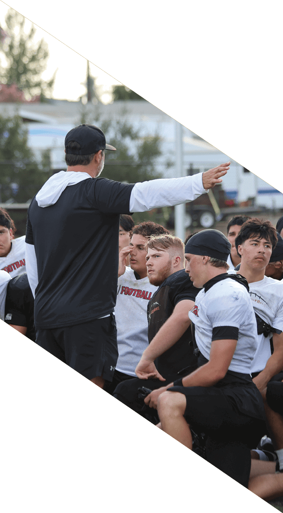 A football player wearing a black helmet and white jersey is holding a football in his hands. AI generated content