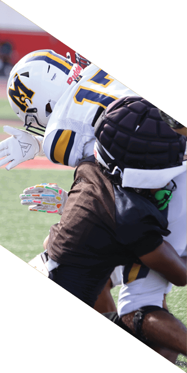 Two football players are on the field, one jumping in the air while the other is running. A referee is also present, watching the play. AI generated content