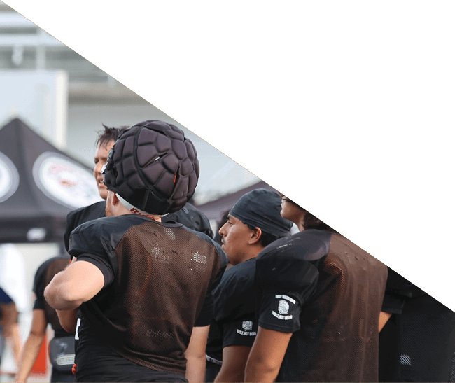 A group of football players kneeling on the field, some with their hands on their heads. AI generated content